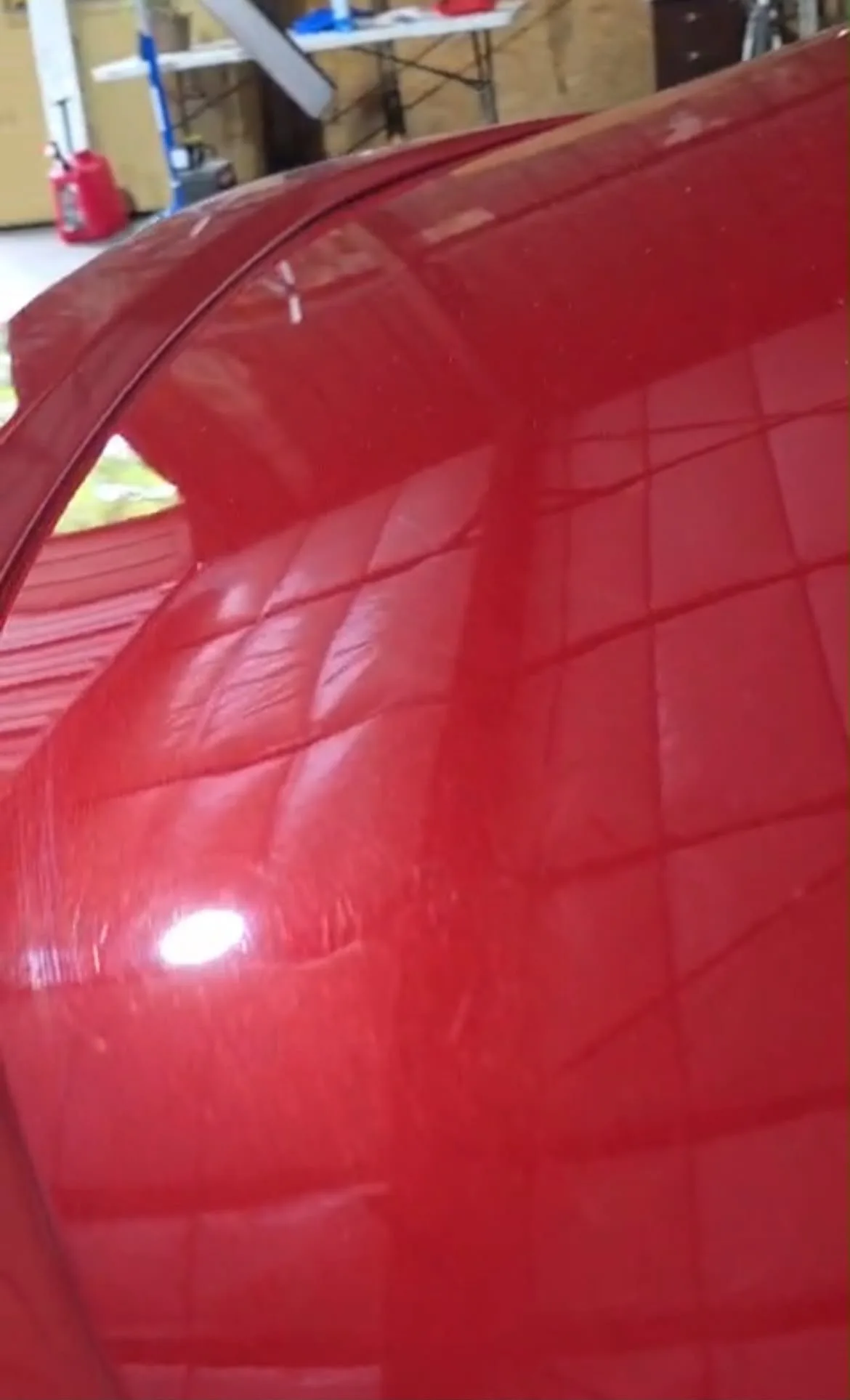 Hail damage on a vehicle roof panel revealed under inspection lighting